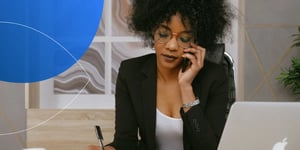 Lady in a suit sitting at the desk on a call