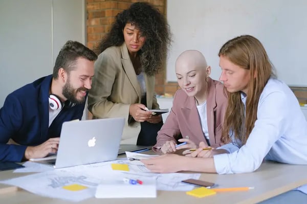 Four employees sitting around table in a discussion  