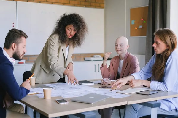 Four employees sitting around table in a discussion  