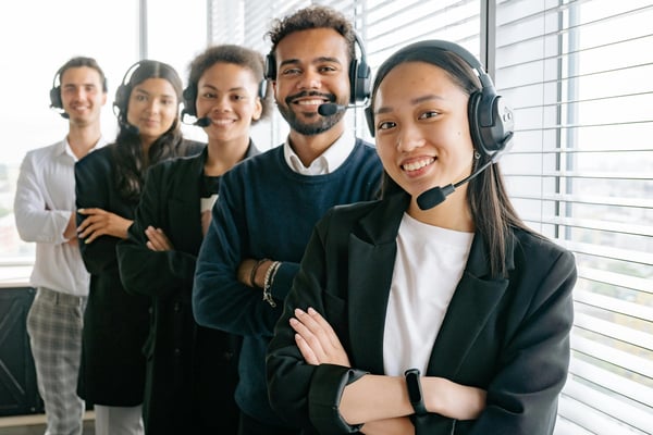 Multiple customer service employees posing for camera while wearing headsets