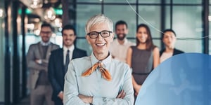 Woman standing in front of people in blurry background smiling 