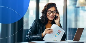 woman talking on the phone holding a paper 
