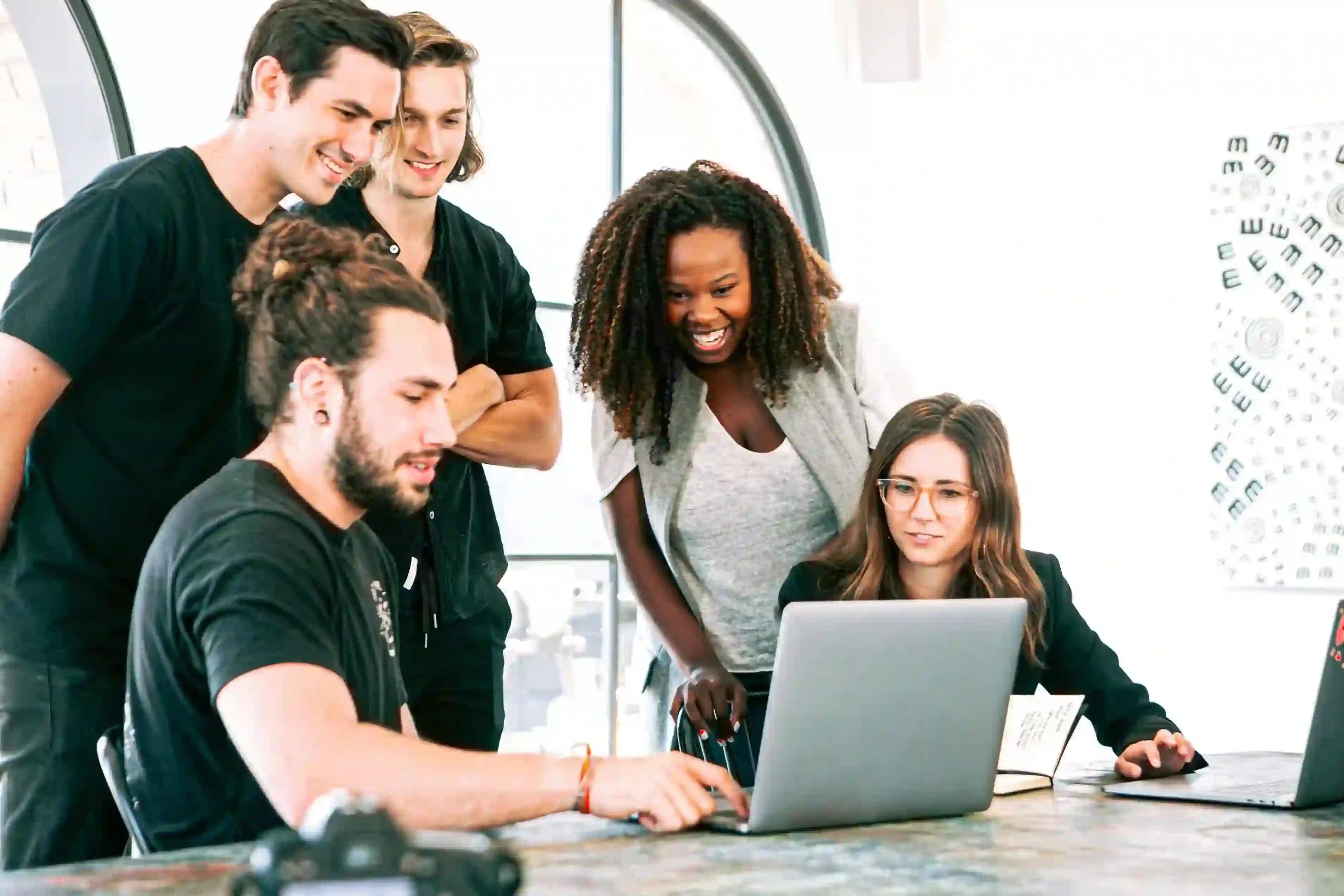 Retorio What is Artificial Intelligence people standing around a laptop smiling and pointing