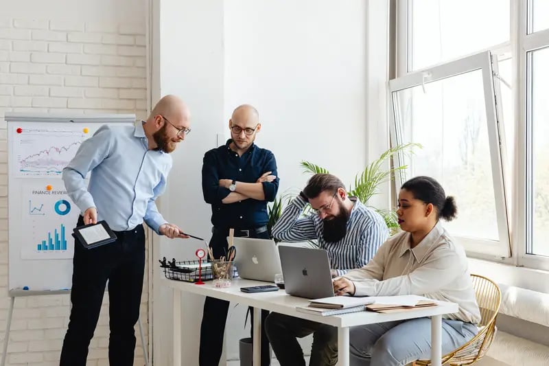 Retorio benefits artificial intelligence group of employees around table discussing 