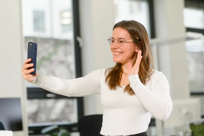 Retorio girl holding a mobile waving and smiling