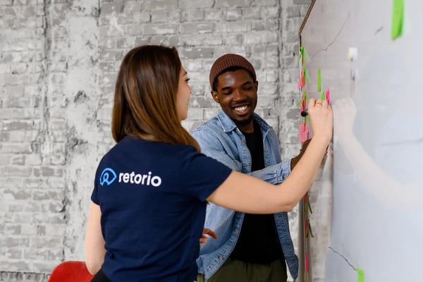 A man and woman writing on a whiteboard