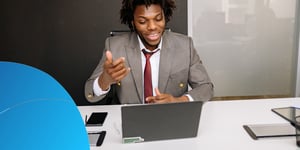 Man in a suit speaking on a video call at his laptop