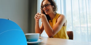 Woman smiling during a video call at a desk by a window
