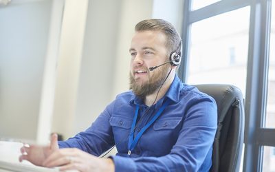 A contact centre rep with a headset explaining a point on a call