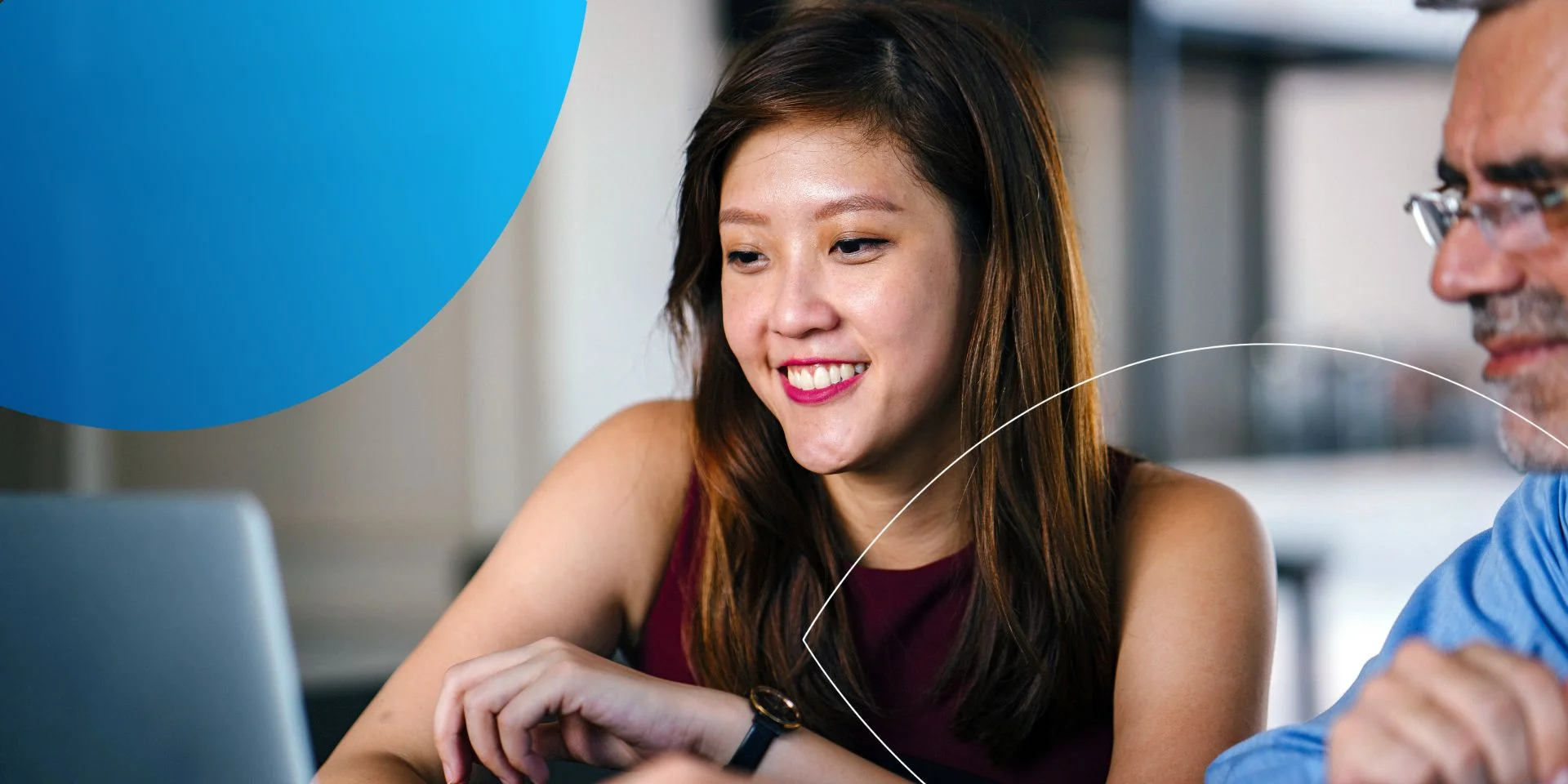 woman sitting next to man and smiling into her laptop screen 