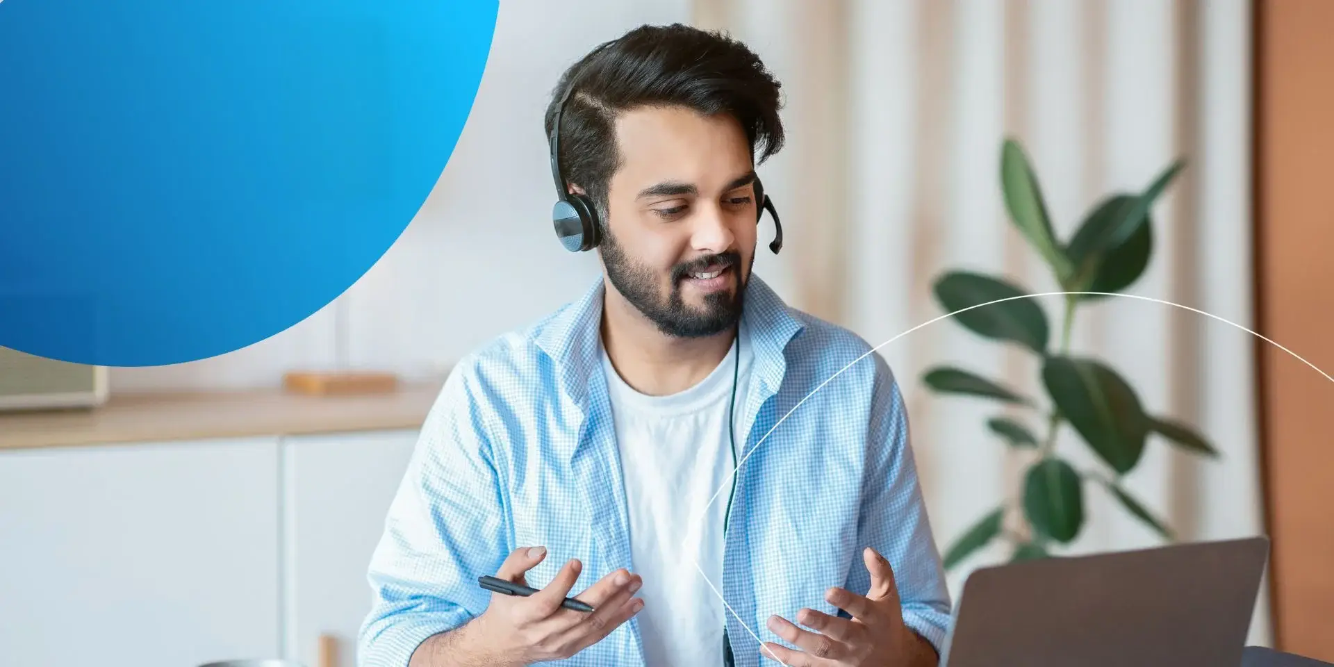 man wearing headset looking into laptop and speaking 