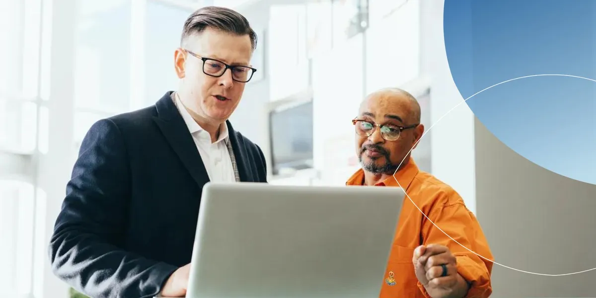 Retorio 2 men standing and looking at a laptop screen