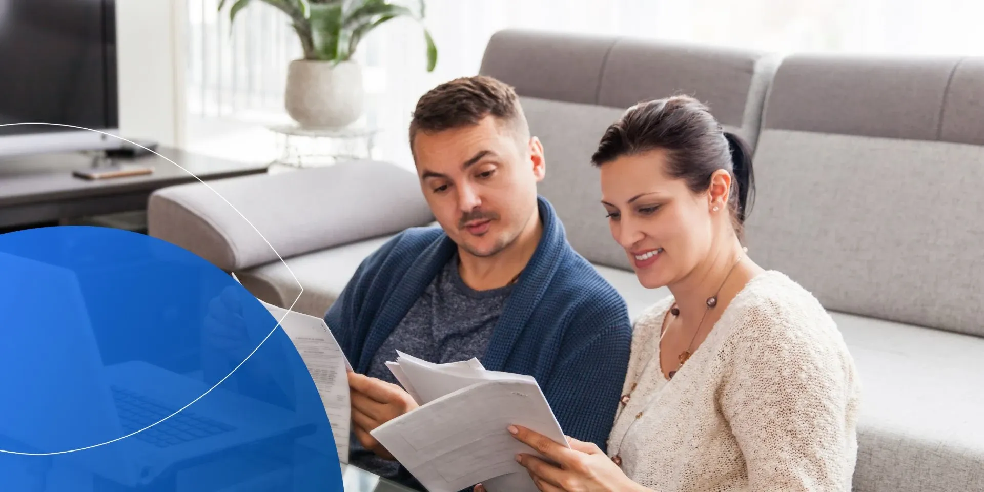 Man sitting next to woman looking through paper documents