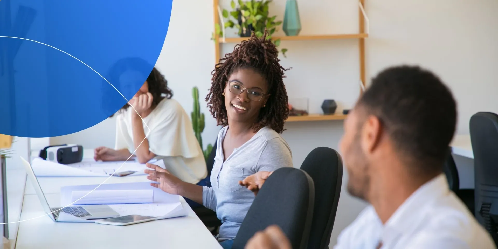 Retorio How AI Enhances Diversity in the Workplace: Unlock Unique Identities woman sitting at desk and talking to her male colleague blurry in front