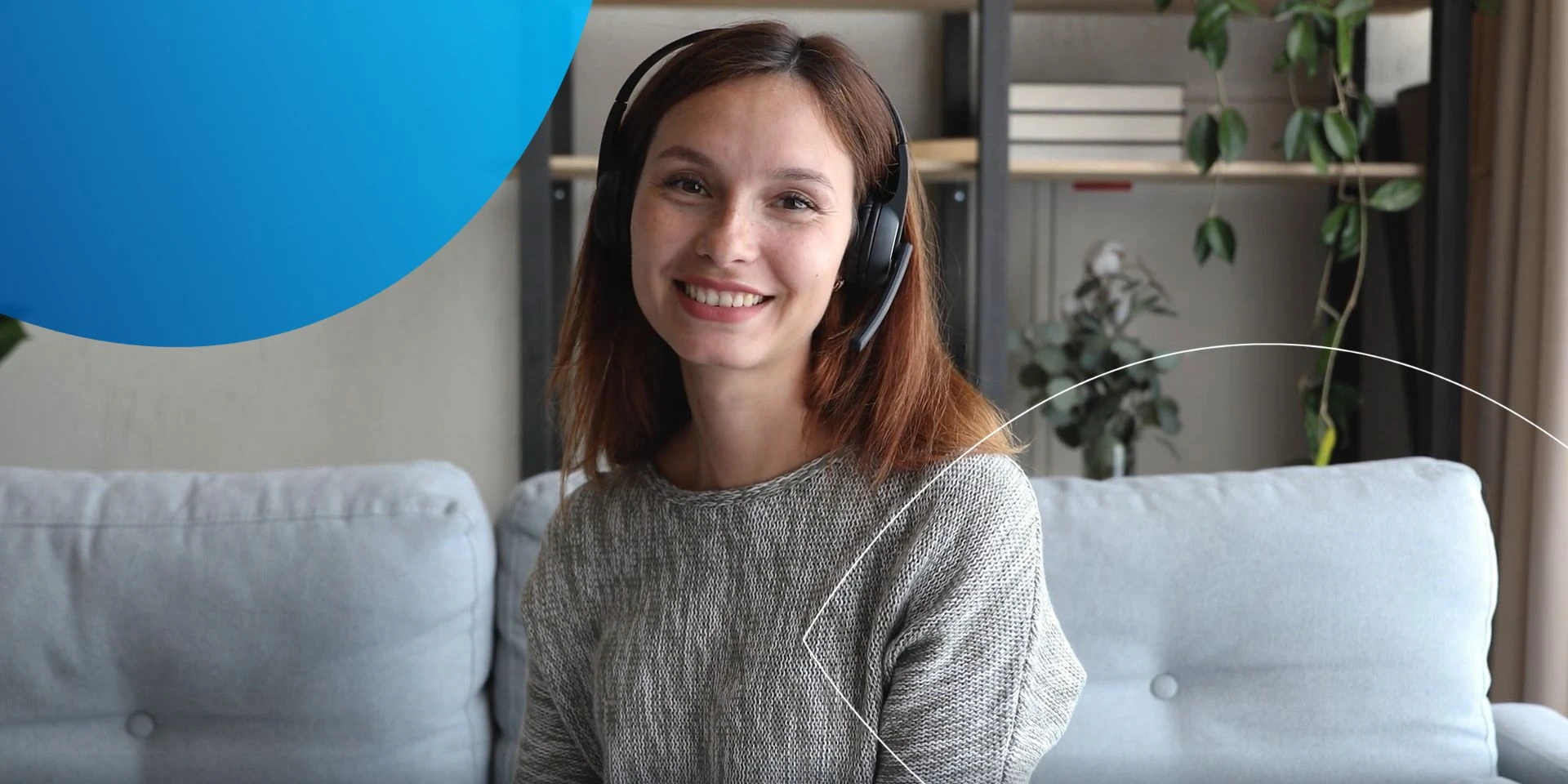 woman wearing black headphones sitting on sofa smiling at camera