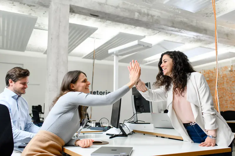 Retorio What is Artificial Intelligence two women giving high five across table