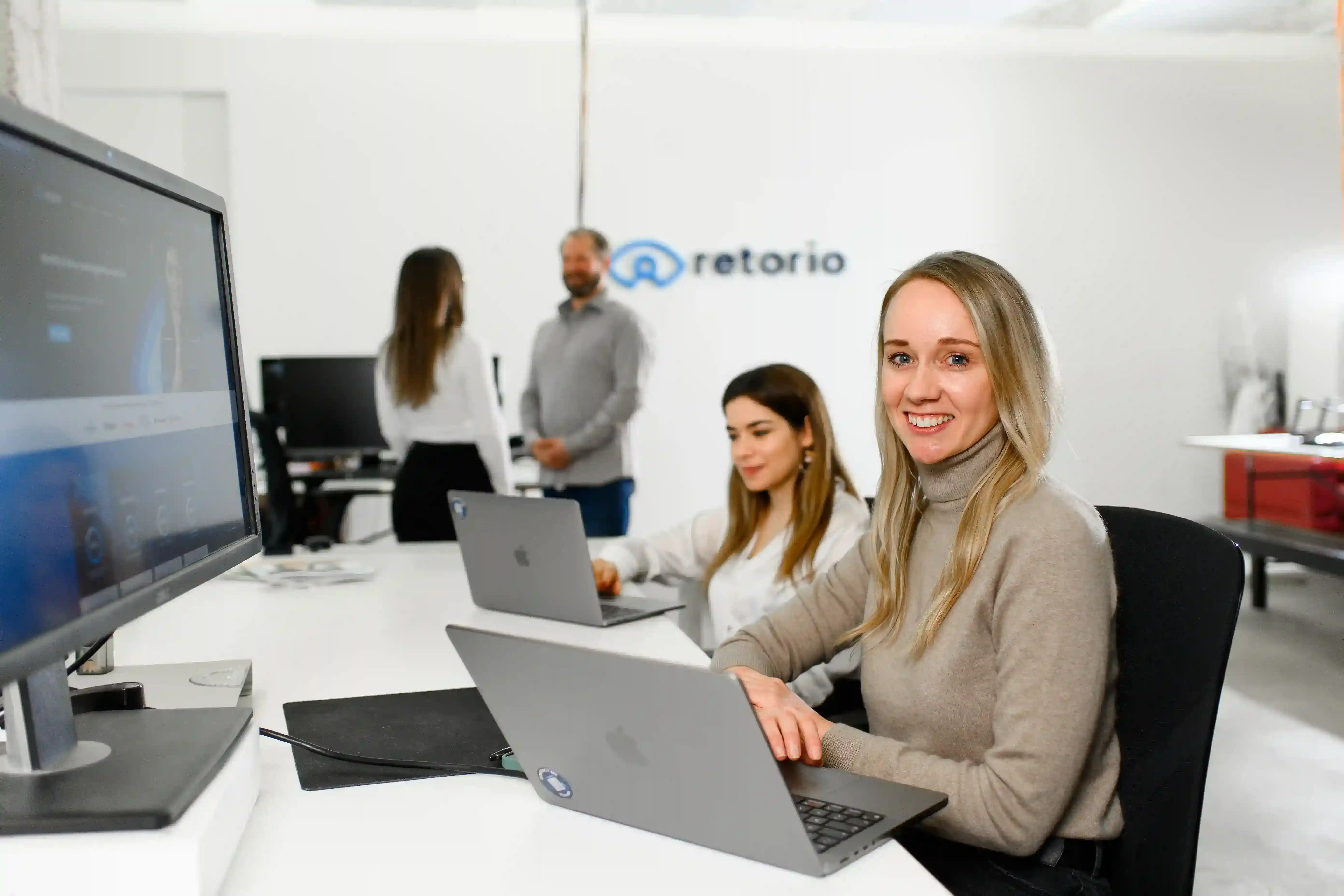 Retorio 5 Ways AI Can Improve HR Operations a young woman sitting at desk smiling into camera 